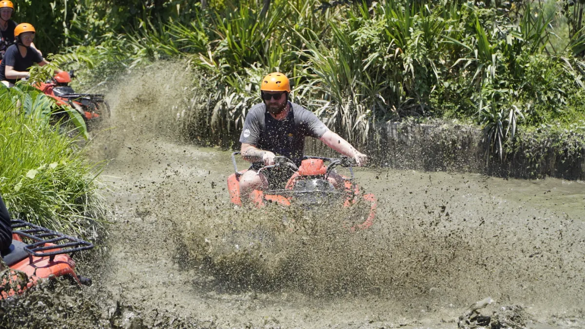 ATV rider making a wide mud splash